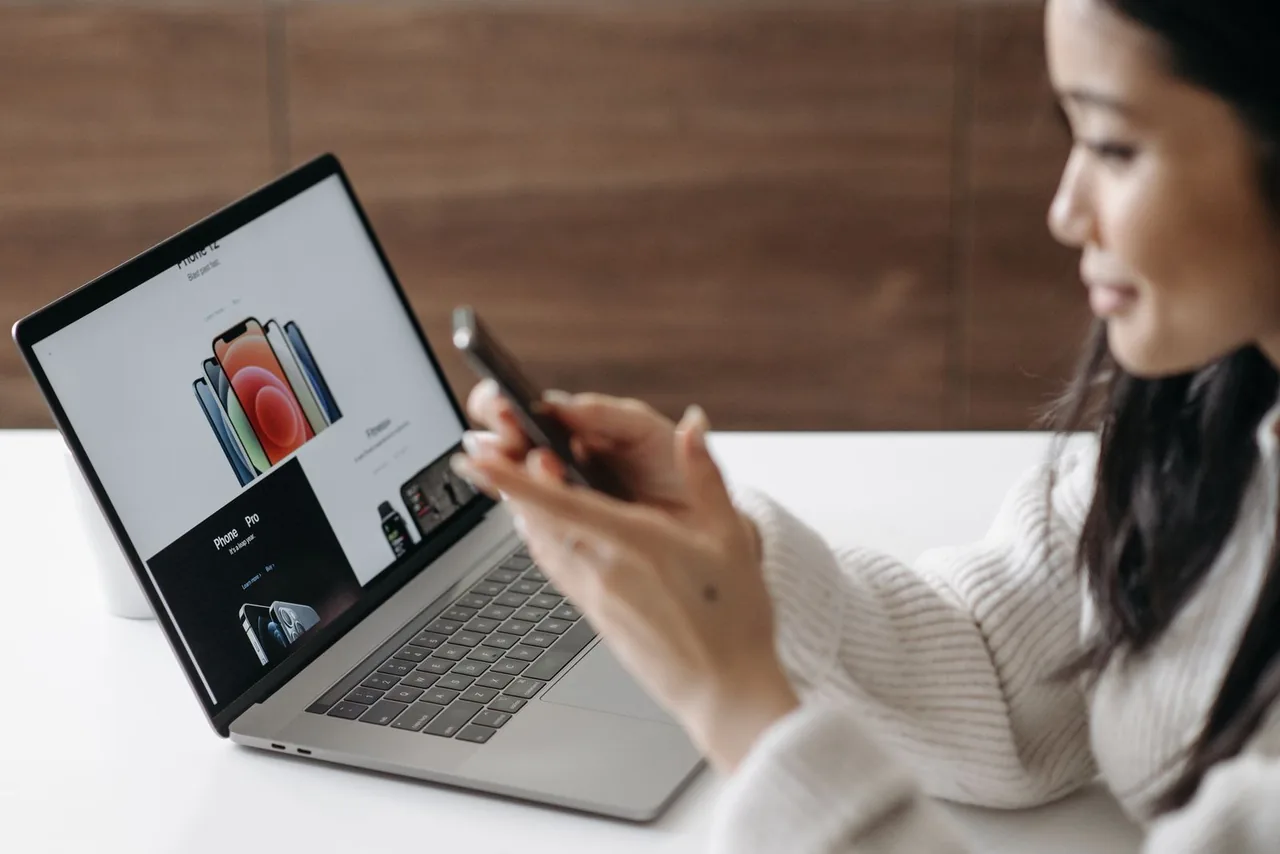 Consultation d’une boutique en ligne sur un smartphone, à côté d’un ordinateur portable.